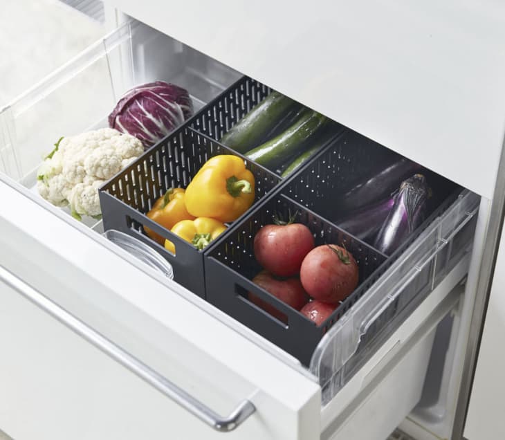 black crates holding produce in fridge