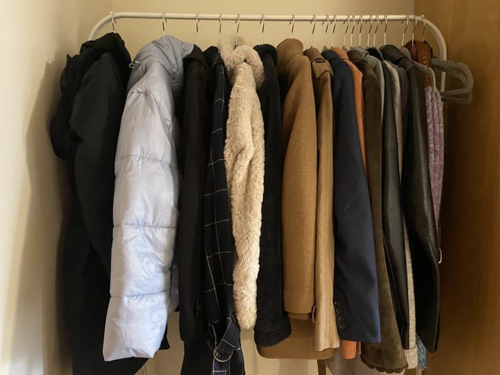 White clothing rack with coats and sweaters.