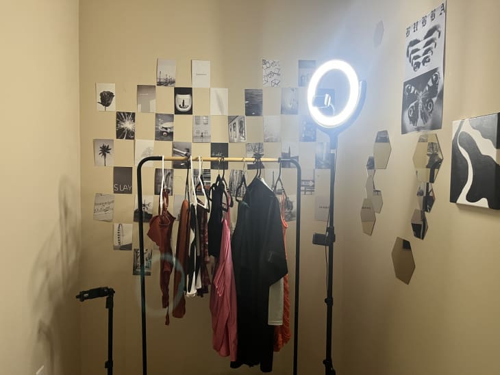 grid of black and white photos, clothing rack gold and black, ring light, posters on wall, reflective hexagons