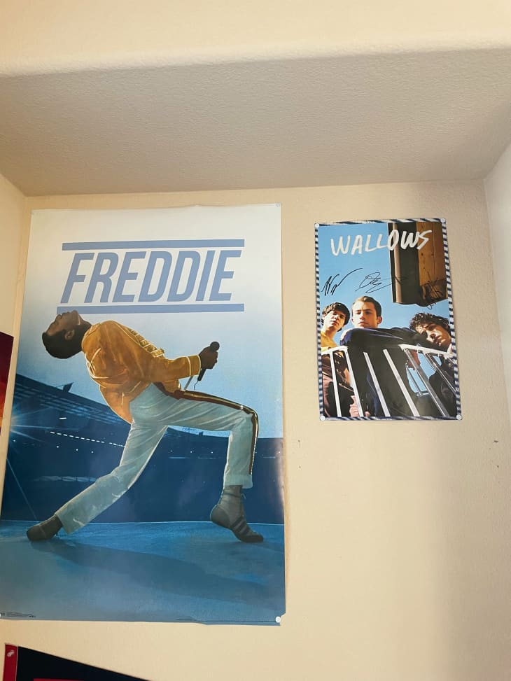 Movie and music posters on wall in dorm room.