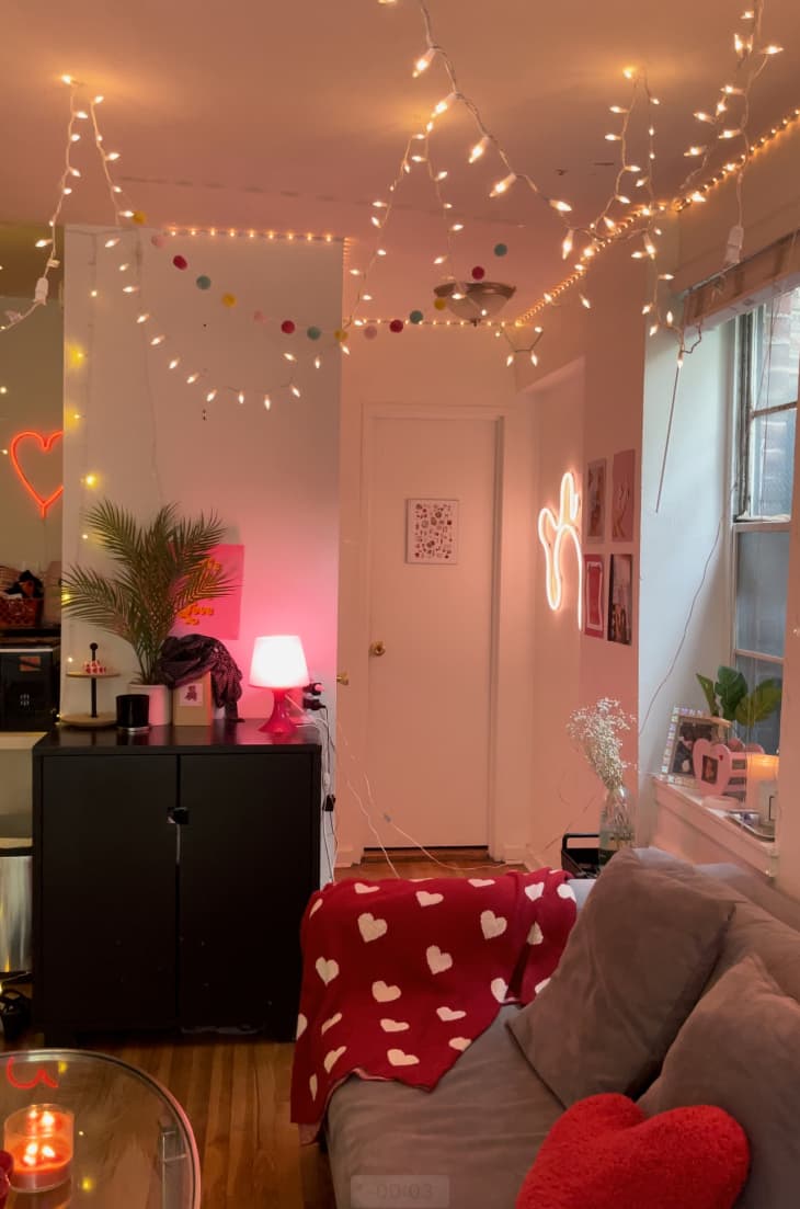 dorm room living area with lots of string lights, neon, and pink light