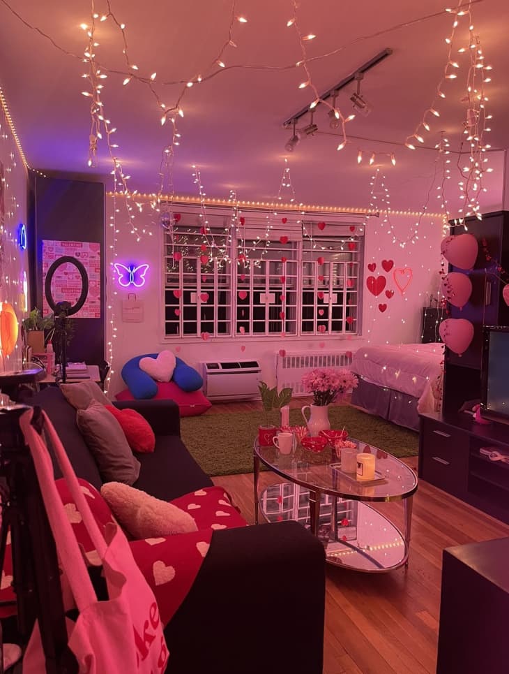 dorm room living area with lots of string lights, neon, and pink light