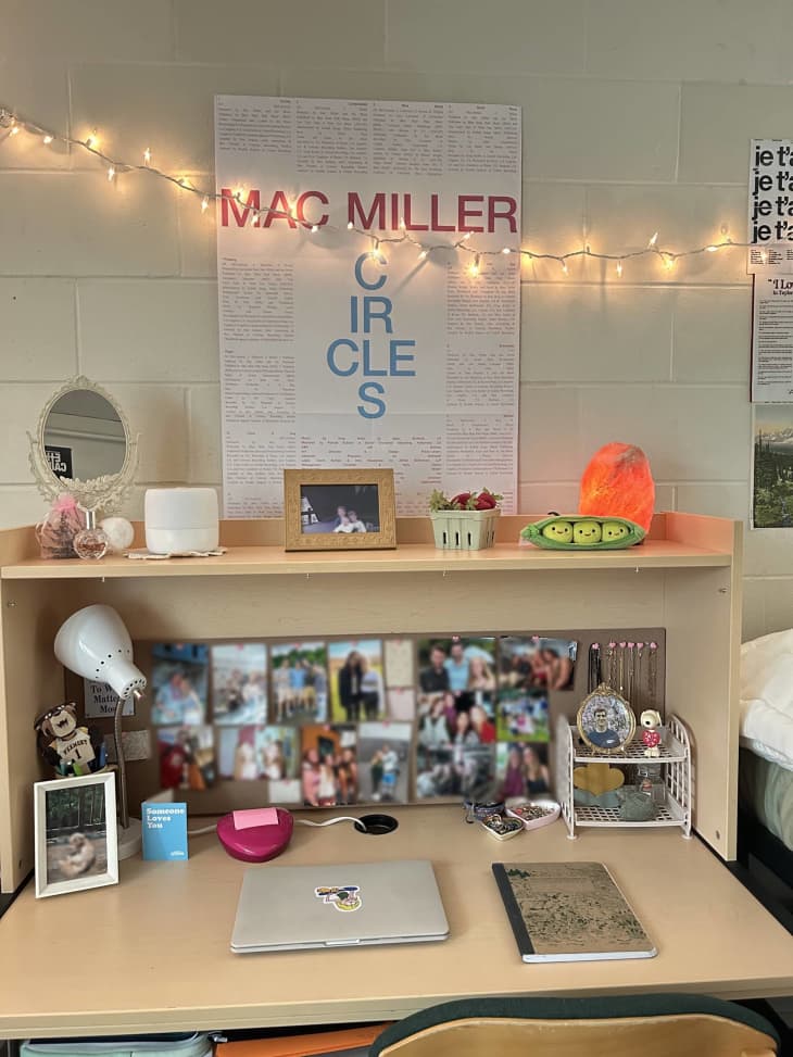 Photographs decorate desk of dorm room.