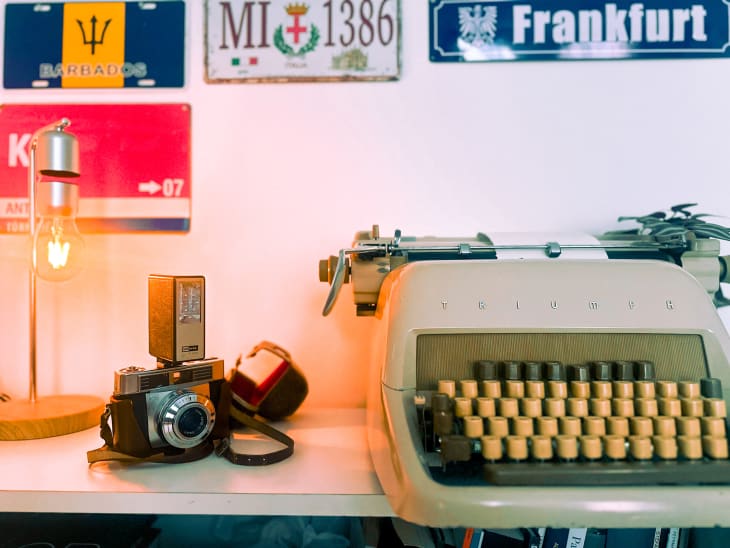 Vintage typewriter and camera on desk.