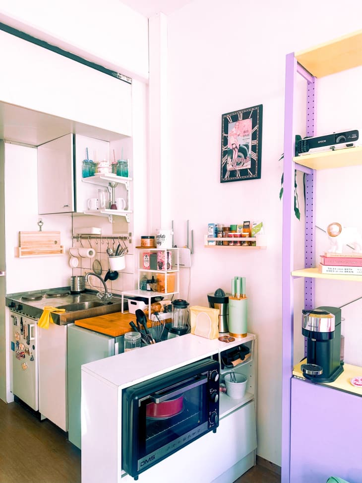 small kitchnette with microwave and purple shelf for coffee station