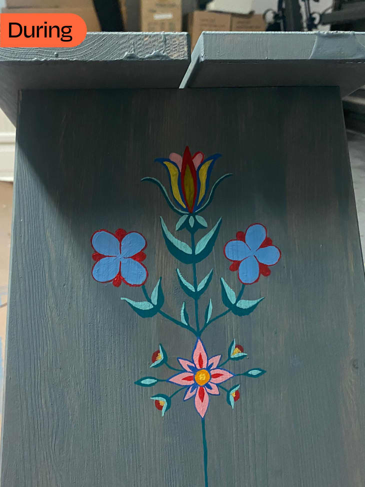 wood nightstand during repainting with blue paint and floral design