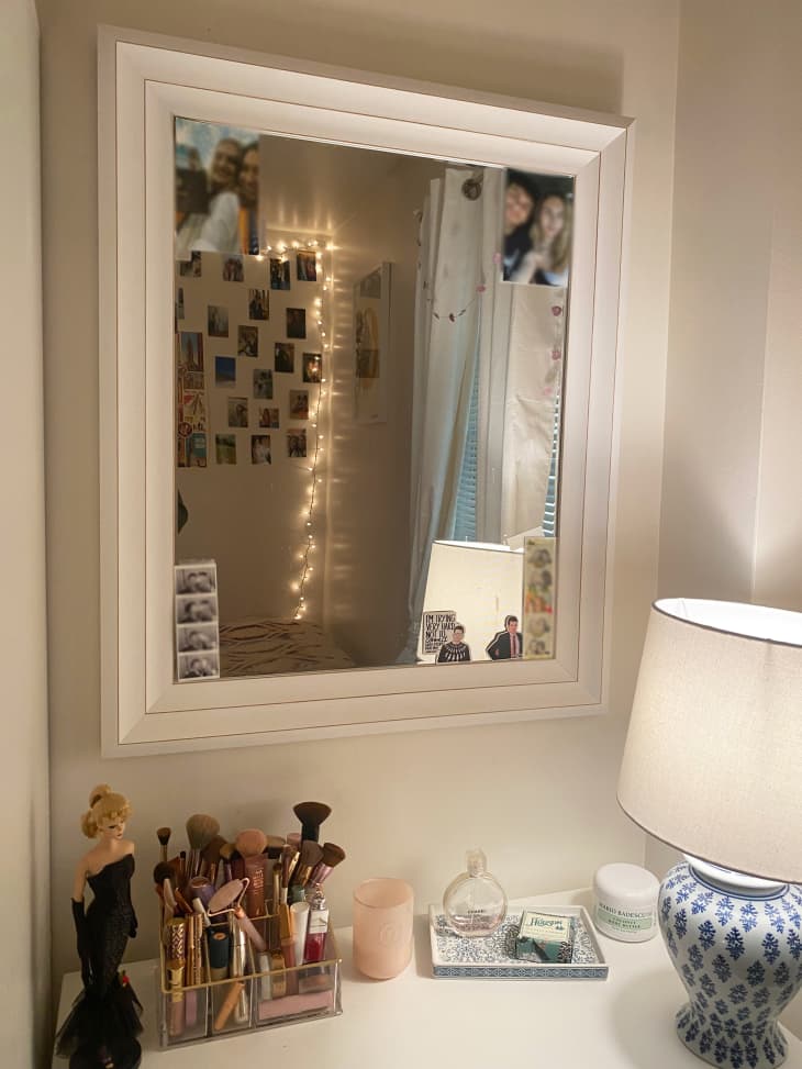 dorm room corner with white framed mirror, vanity area