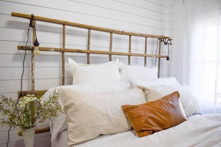 a white bed has a headboard made of bamboo