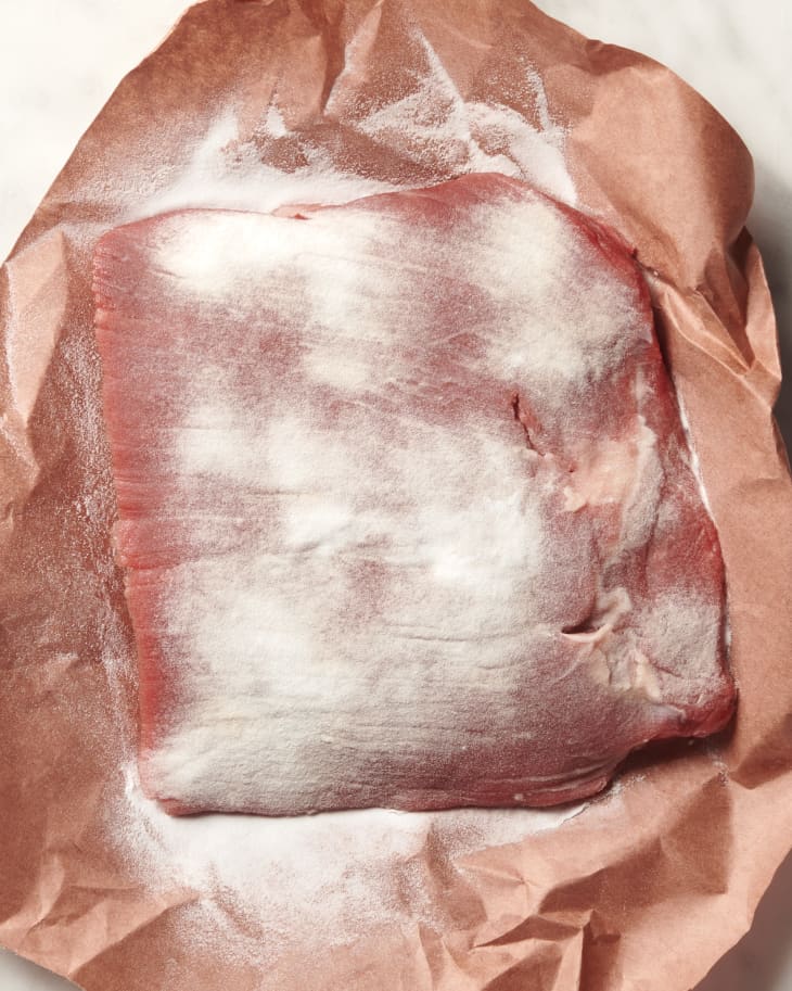photo of a raw steak on butcher paper with a layer of baking soda sprinkled on top