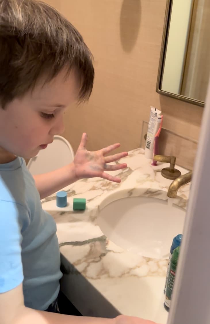 kid washing his hands at the bathroom sink