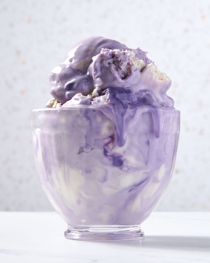 shot of ube swirl ice cream in a ice cream glass with some ice cream dripping down the sides