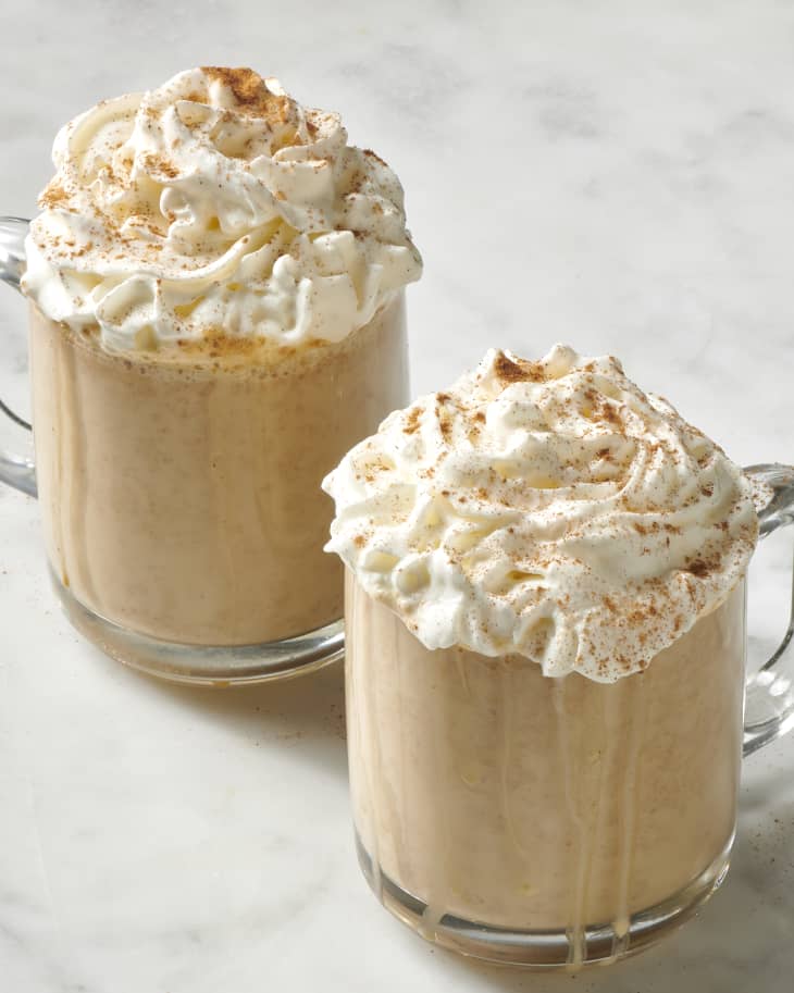 pumpkin spice lattes with whipped cream on marble surface