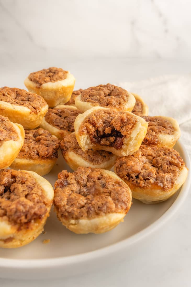pecan tassie cups on plate with bite taken out of one