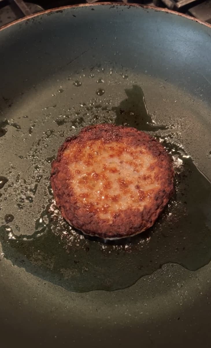 sausage patty frying in skillet