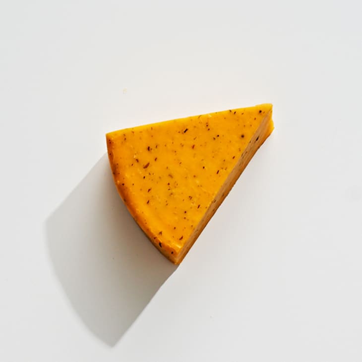 An overhead photo of flavored cheese on a white surface.