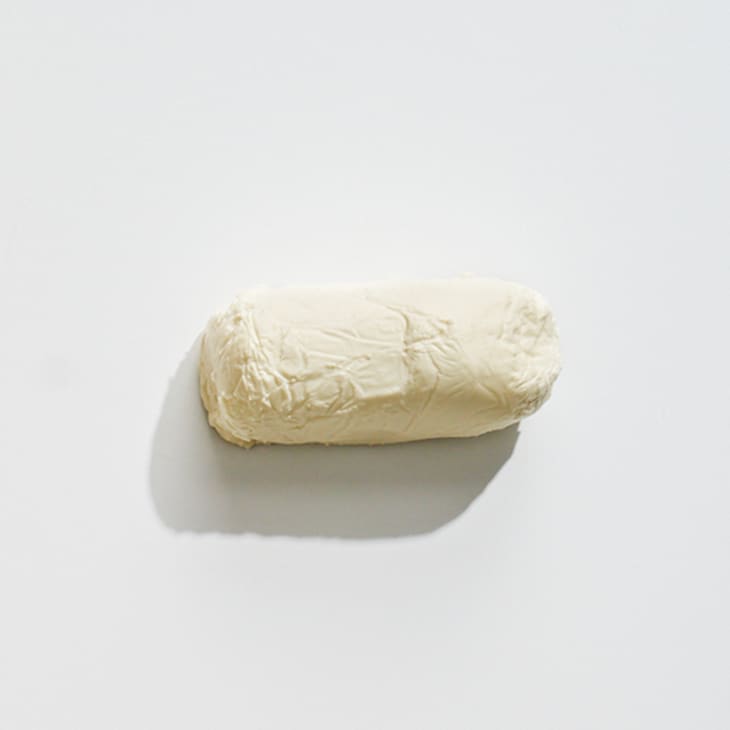 An overhead photo of goat cheese on a white surface.
