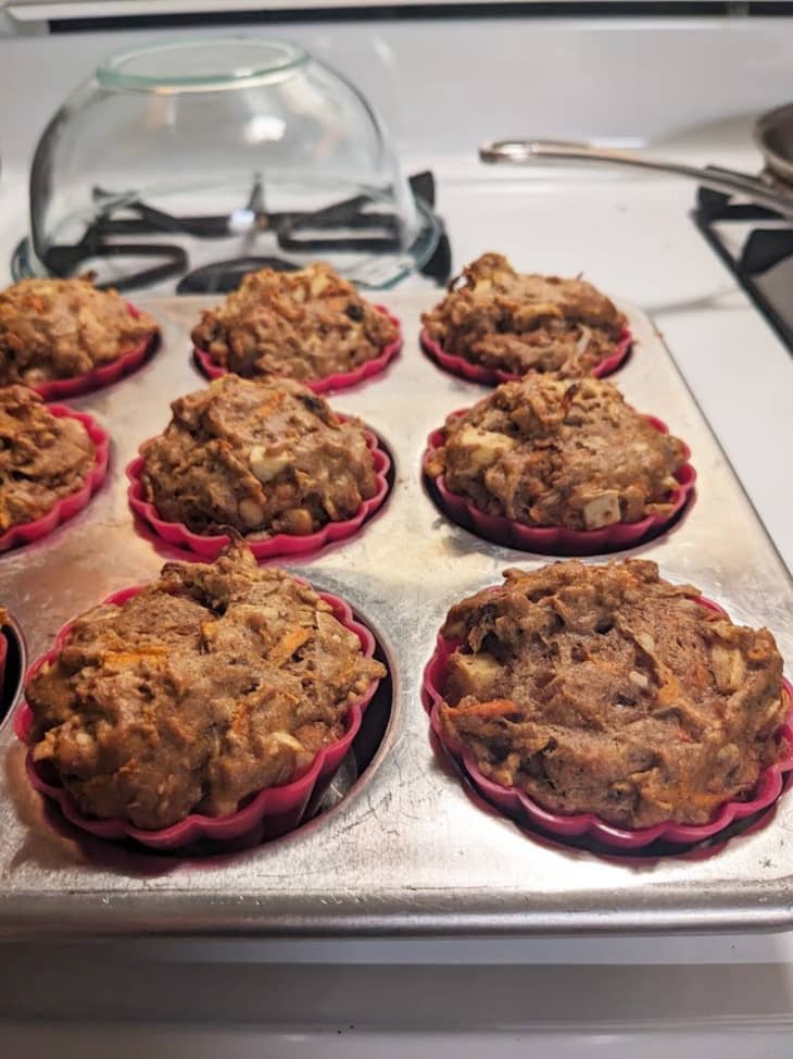 muffins in tin with red cup holders on stove
