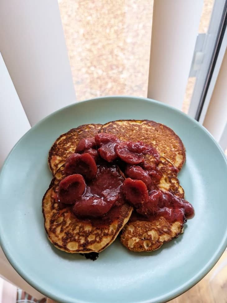 blue plate of pancakes with fruit compote on top