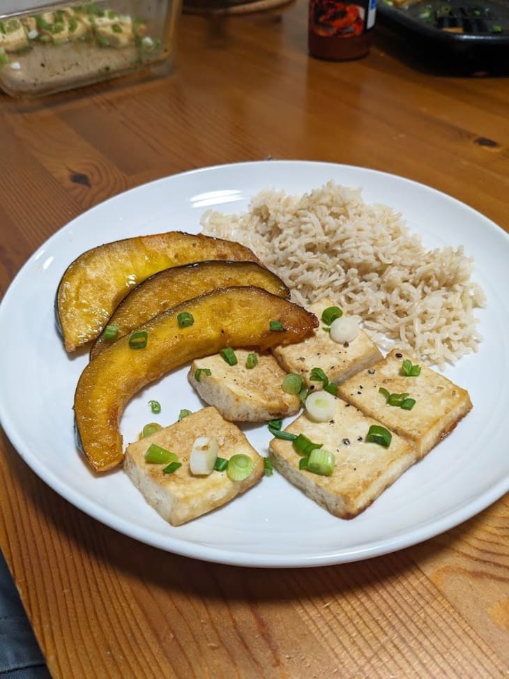 squash pieces, rice, and tofu with scallions on top