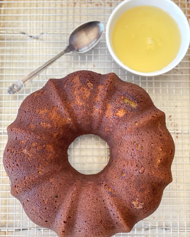 baked cake base on a cooling rack next to icing and spoon