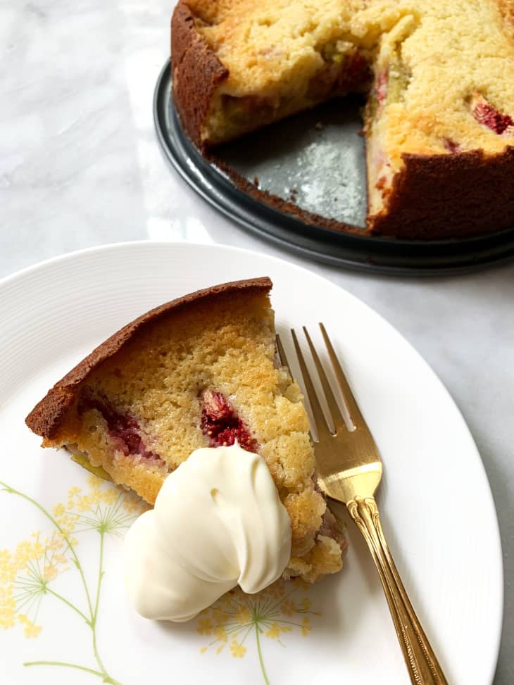 Slice of Ina Garten's fig and ricotta cake on plate with whole cake in background.