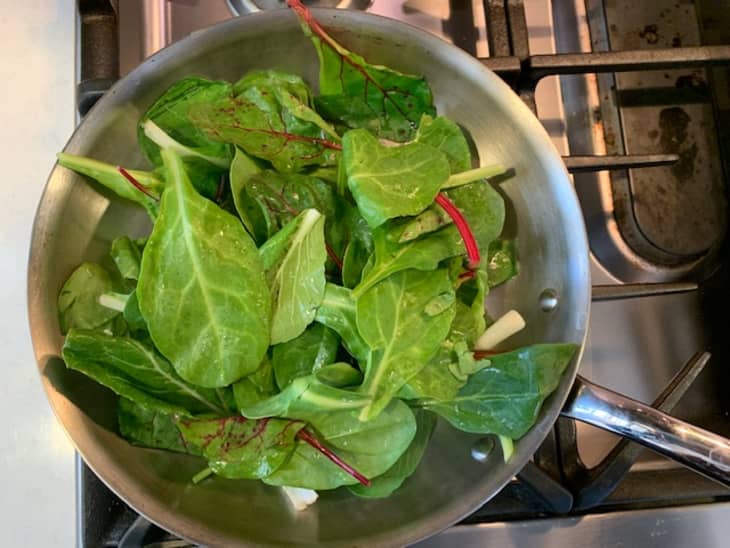 uncooked mixed greens in saute pan