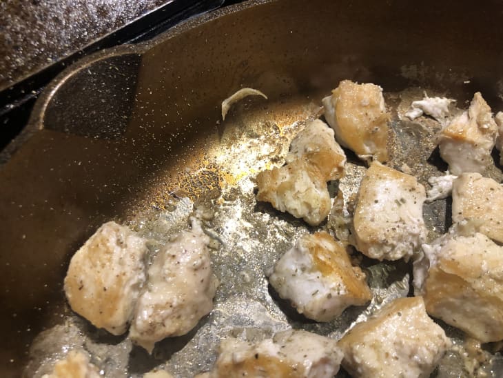 chicken cooking in Smithey cast iron skillet