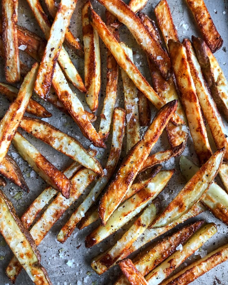 french fries sit cooked on a baking sheet