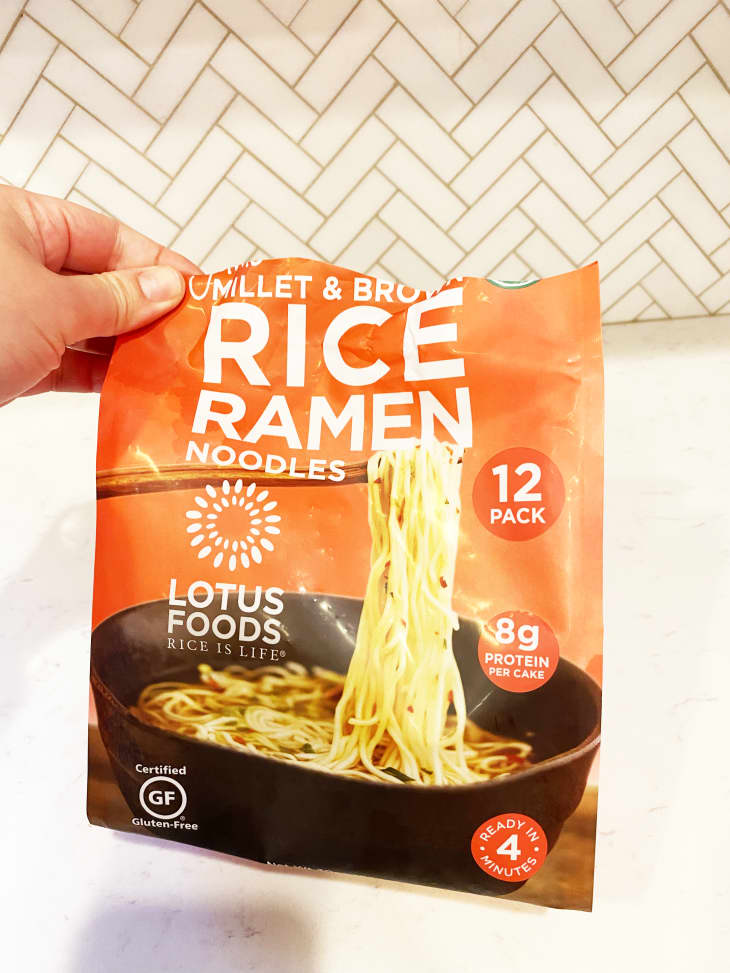 hand holding open bag of millet and brown rice ramen
