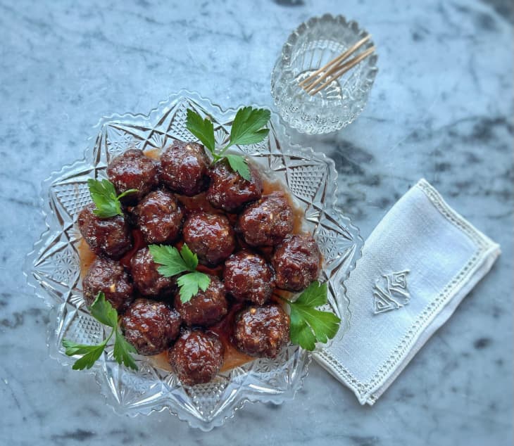 plate of cocktail meatballs next to napkin and toothpicks