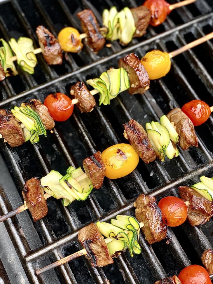 Photograph of steak kebabs in on the grill.