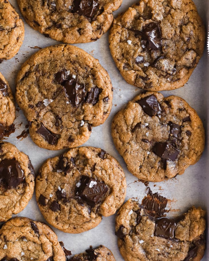 Photograph of brown butter chocolate chip cookies on white parchment paper.