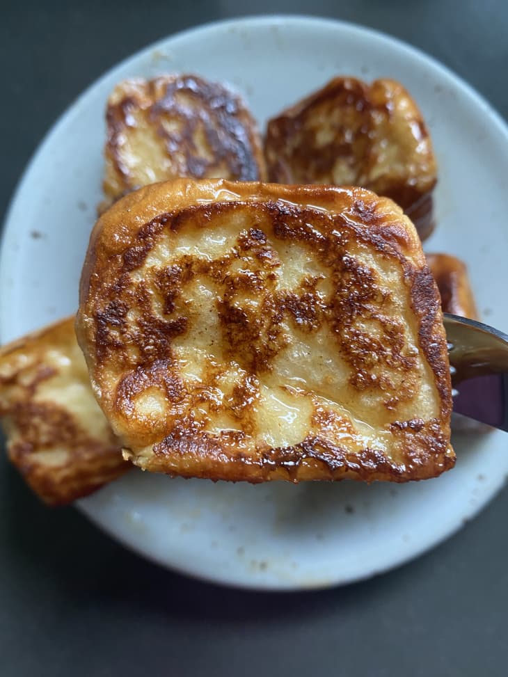 close-up photograph of Hawaiian roll french toast bite with others bites in the background on a plate
