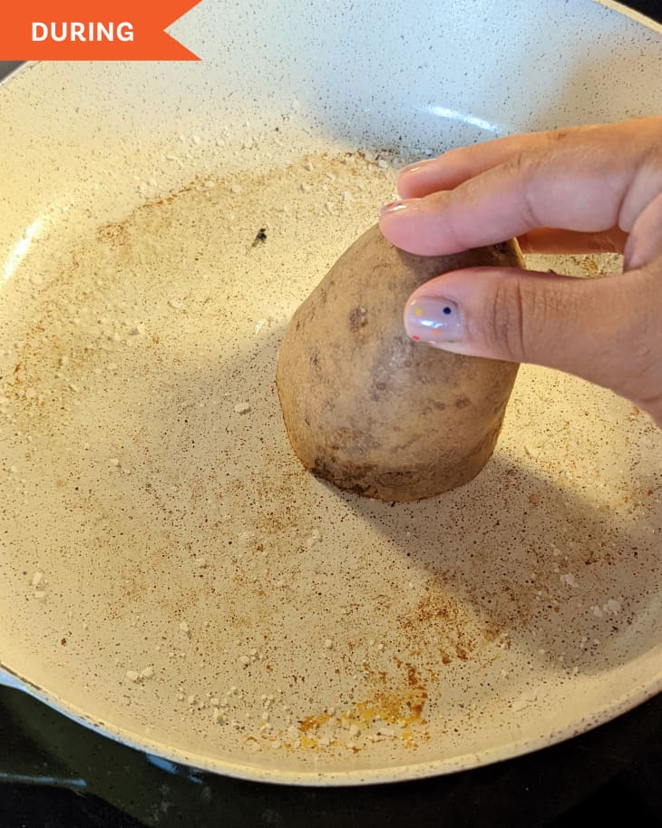 Using potato to clean skillet.