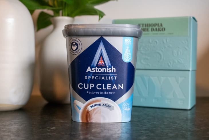 package of Astonish Cup Clean in front of a plant and box of coffee