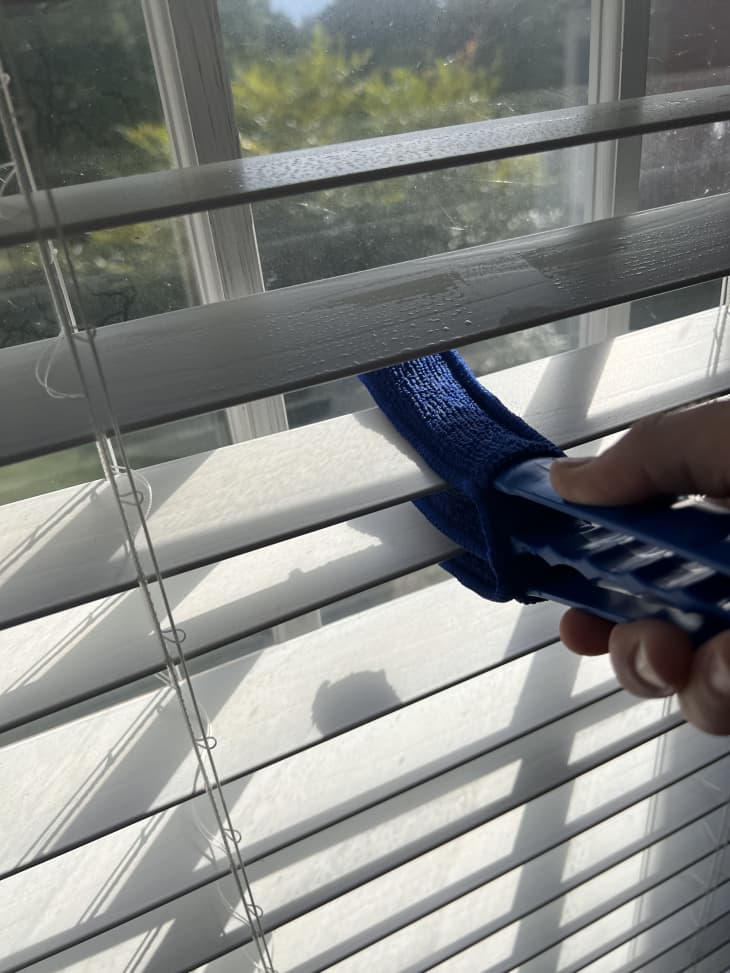 dusting tool in action on white blinds