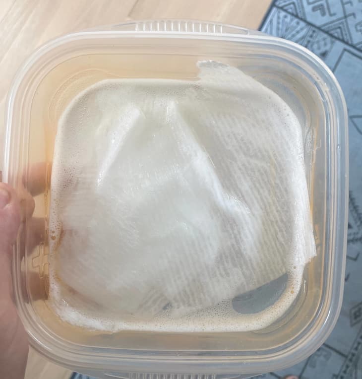 paper towel and soapy water in Tupperware container