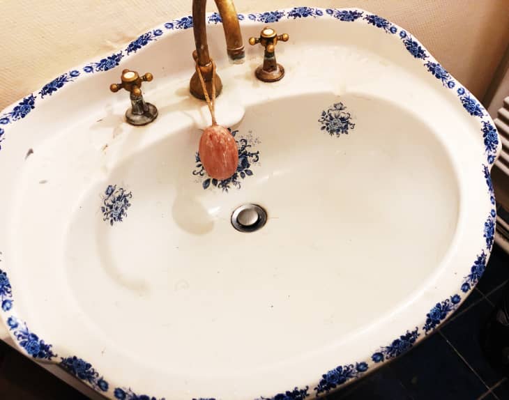 white sink with blue floral trim before cleaning