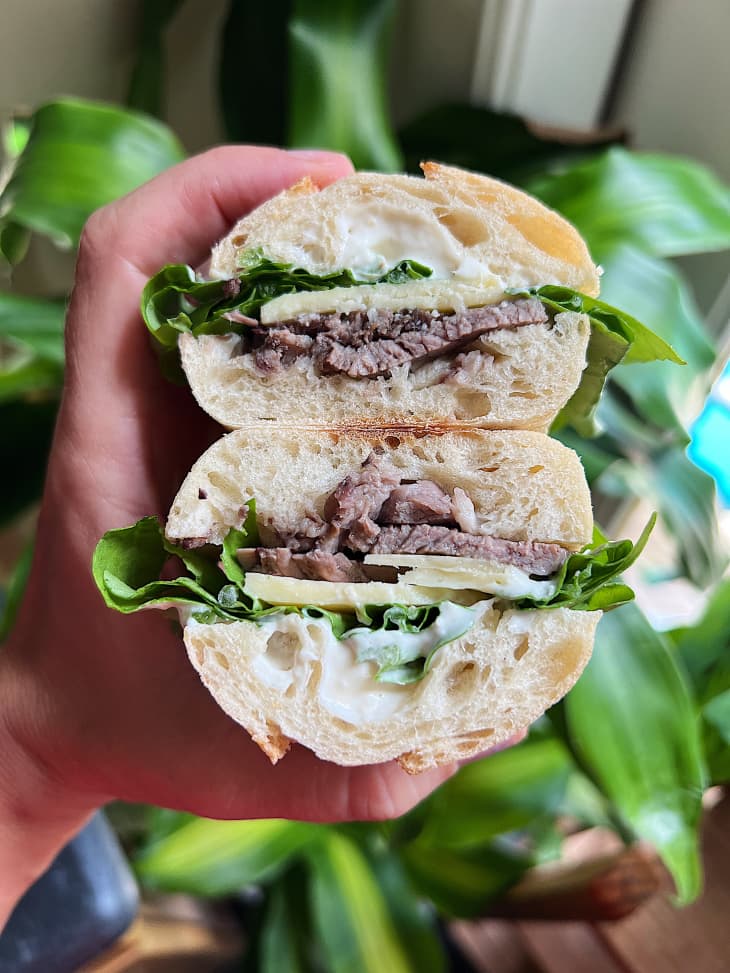 lamb sandwich on baguette with cheese and greens