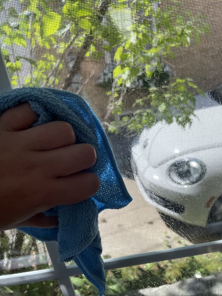 washing a window with a microfiber cloth