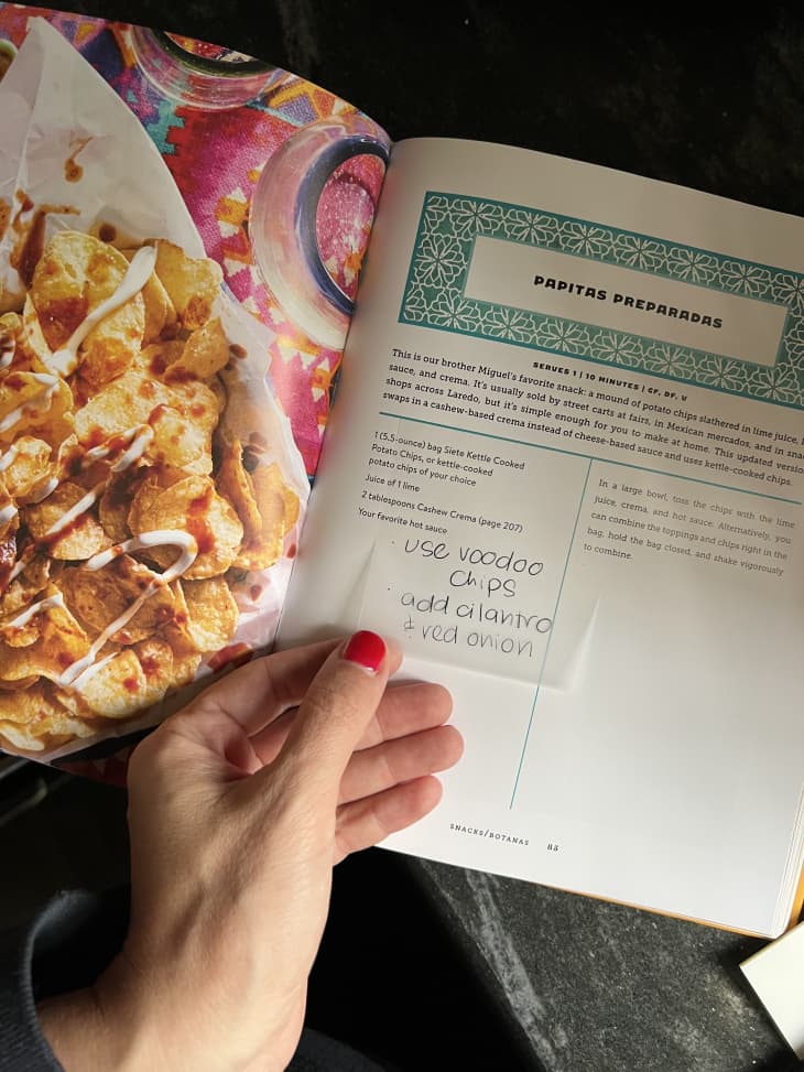hand adding a note on a transparent post-it on a cookbook page
