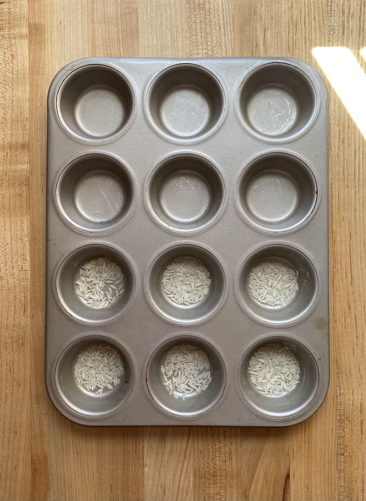 muffin tin - half of the holes filled with grains of rice