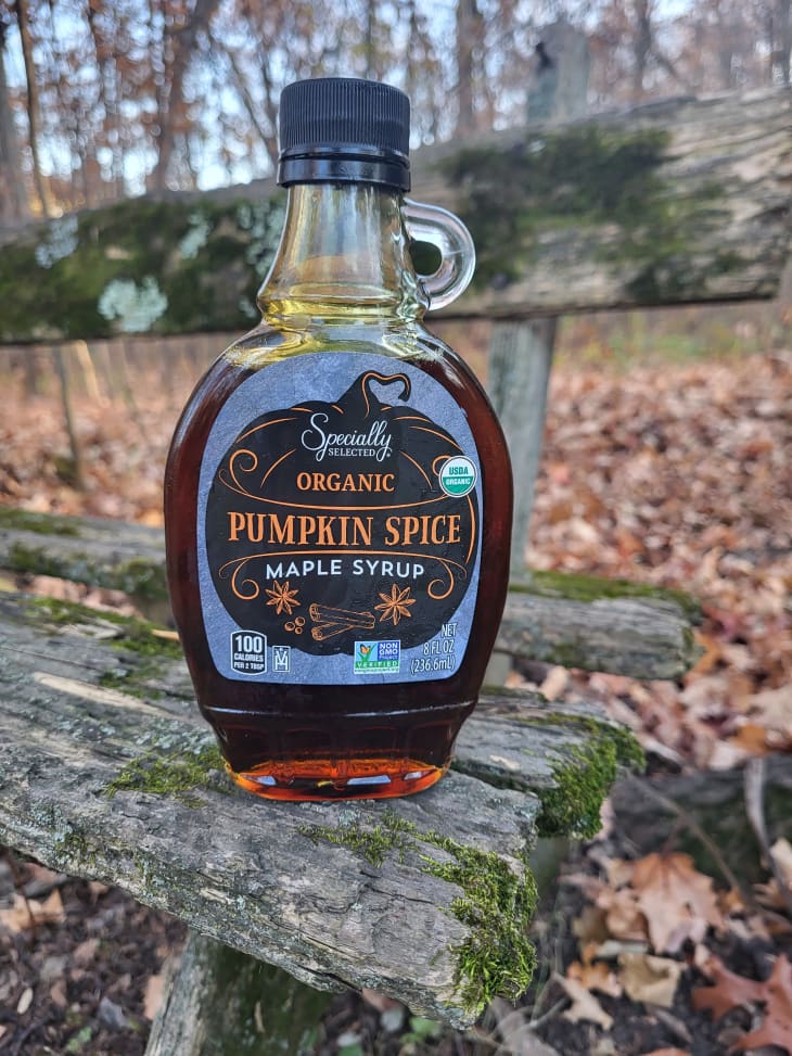 bottle of Aldi pumpkin spice maple syrup on wooden bench outside
