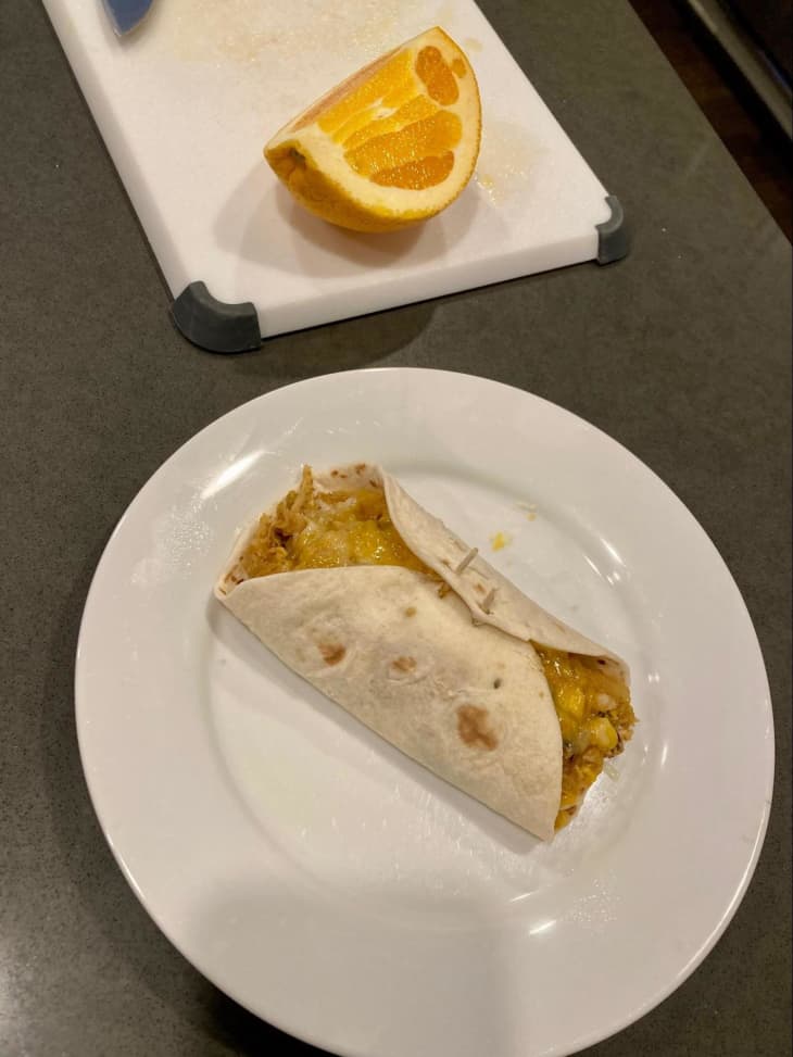 breakfast burrito with a sliced orange