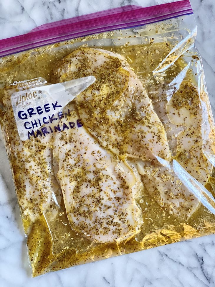 Greek chicken marinating in a zip-top bag.