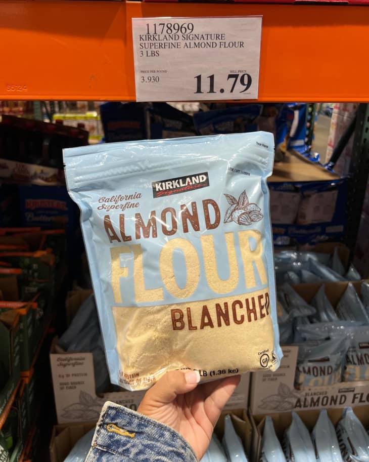 A bag of Kirkland Almond Flour being held up for the camera in a Costco store