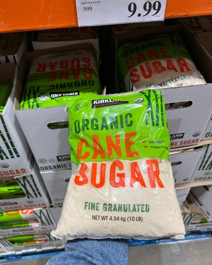 A bag of Kirkland Organic Cane Sugar being held up for the camera in a Costco store