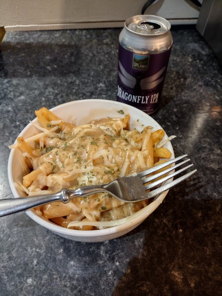 bowl of cheesy pasta with fork. Can of IPA beer in background