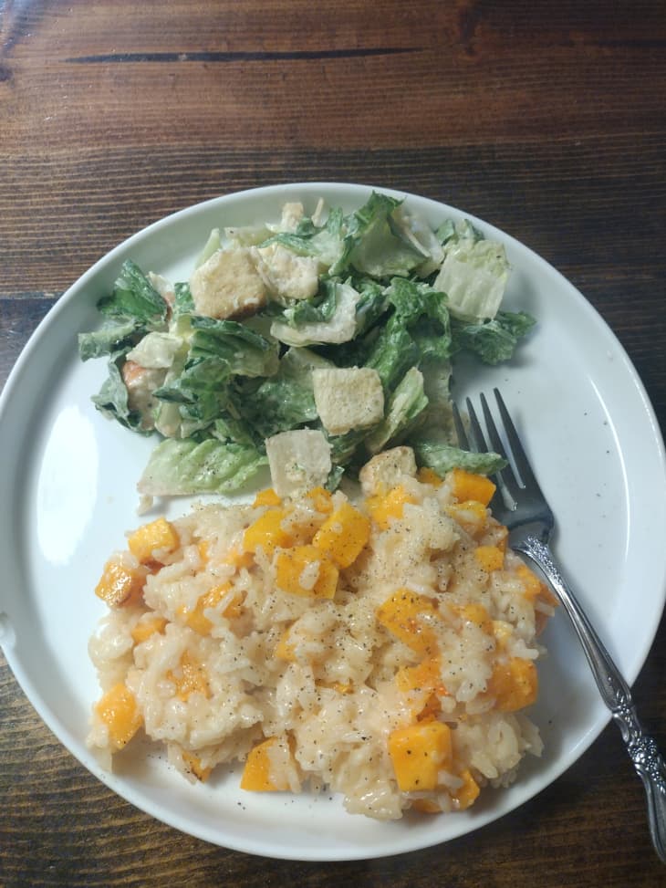 Risotto and caesar salad on plate