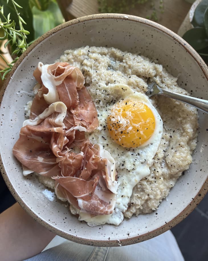 Fried sunnyside up egg over cooked oat bran with prosciutto